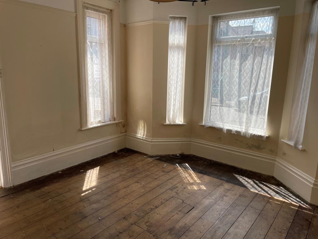 Lot: 139 - RETAIL UNIT AND WORKSHOP WITH GARAGE AND TWO FLATS - Front living roonm on ground floor with bay window